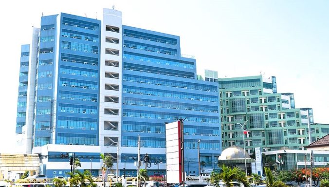 KLINIK in Santiago d. Caballeros (800.000 Einwohner) Klinik mit großen Glasfassaden und hellem Himmel im Hintergrund.